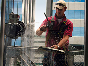 zdjęcie: mężczyzna myjący okno biurowca