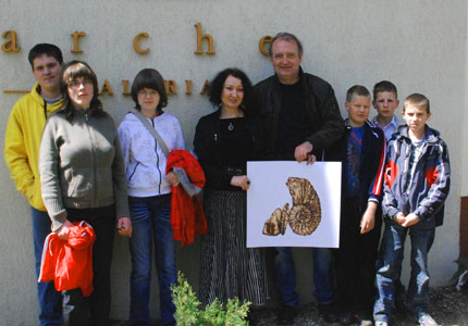 Na zdjęciu: Dzieci i organizator Dariusz Młynarczyk odbierają prace na aukcję od prof. Krystyny Szwajkowskiej, właścicielki galerii Arche. Fot.: arch. organizatora.