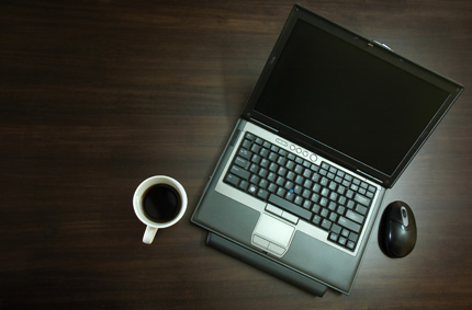 Laptop i filiżanka kawy na biurku. Fot.: www.sxc.hu