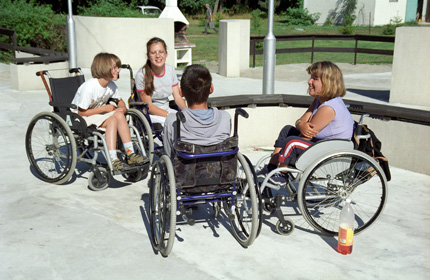 Dzieci z niepełnosprawnością na wózkach rozmawiają ze sobą