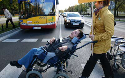 kobieta przechodzi przez przejście z synem z niepełnosprawnością