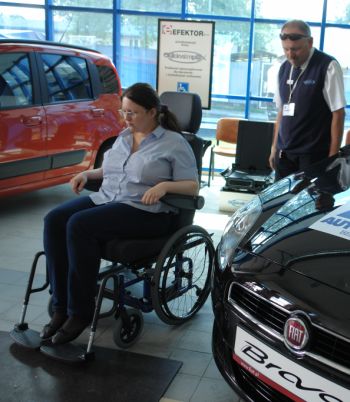 Prezentacja fotela służącego do wprowadzania osoby z niepełnosprawnością do samochodu.